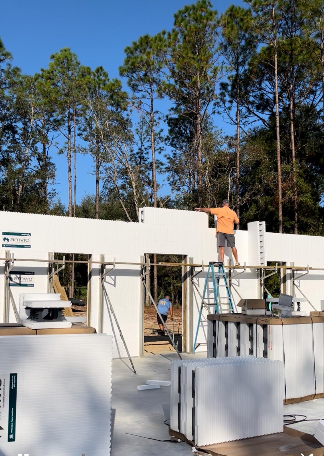 Workers assembling ICF walls with bracing supports