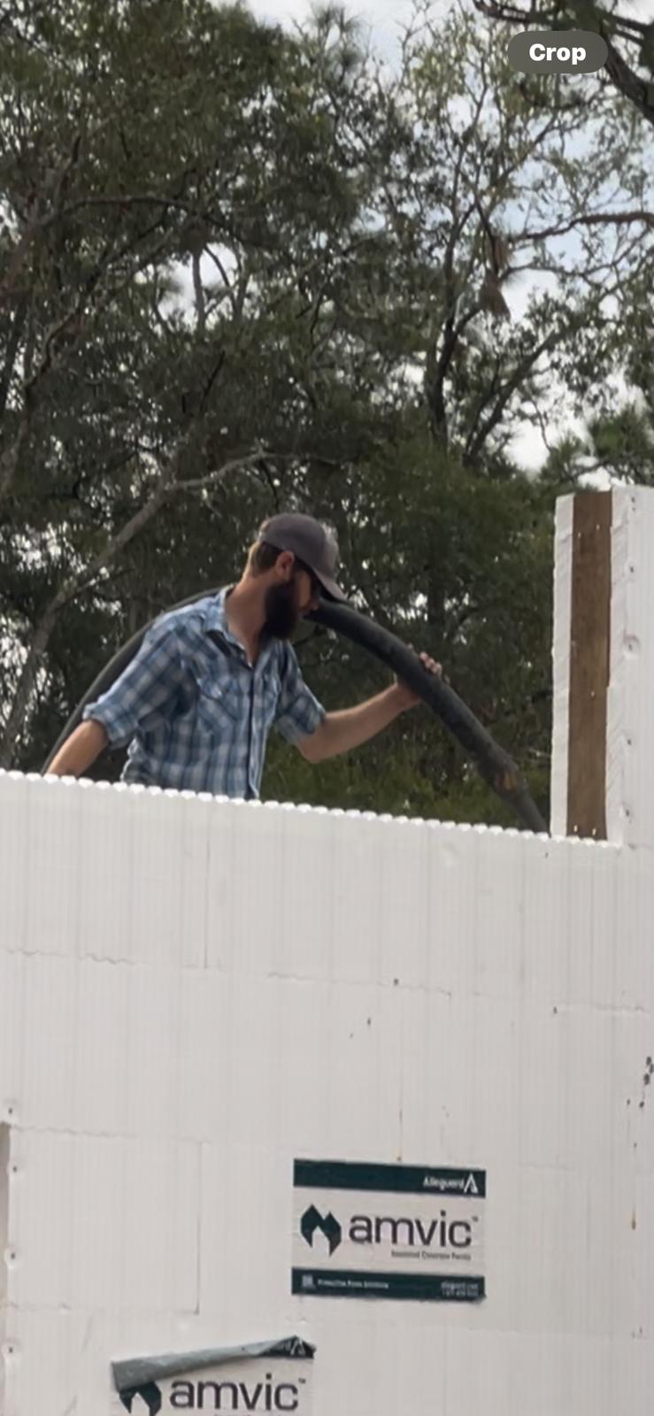 Worker pouring concrete into ICF forms